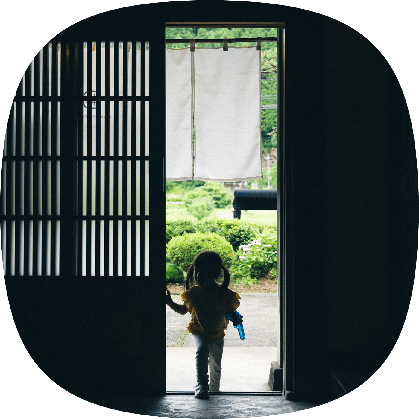 玄関から屋内に入ってくる女の子の後ろ姿